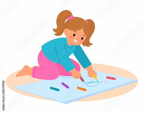 A young girl with pigtails sits on the floor, drawing with crayons on a large sheet of paper, smiling happily.
