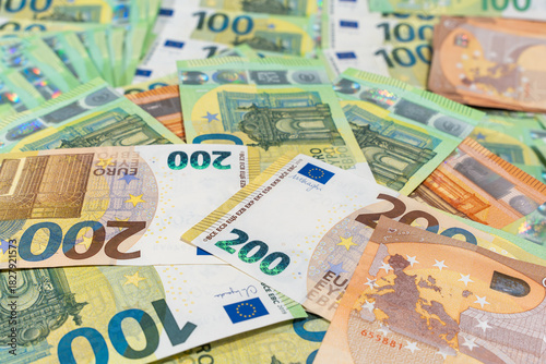 Scattered euro banknotes fill the frame in a bright flat lay. Background image for cash payments, currency, inflation, and European finance.