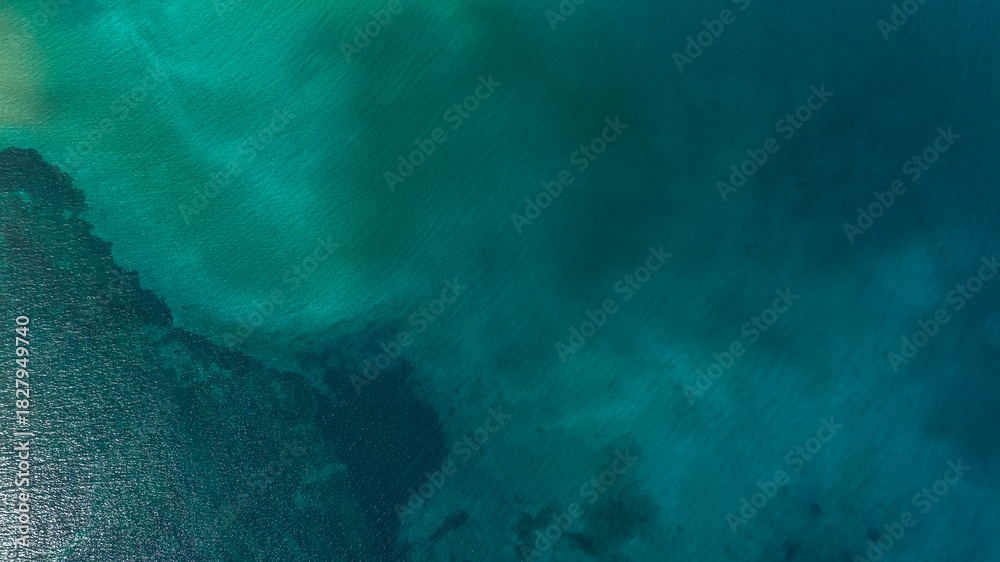 Obraz premium Aerial view of the azure and turquoise surface of water. Sea concept. Ideal for backgrounds, textures and patterns of tropical seas.