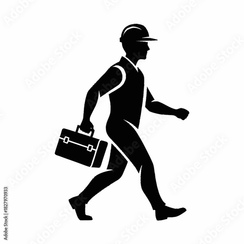 Silhouette of a construction worker carrying a toolbox walking.