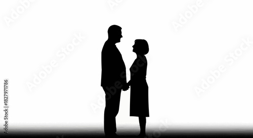Silhouette of an elderly couple holding hands and looking at each other.