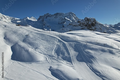 Aerial drone view of snowy alpine terrain near Zermatt, Switzerland, showcasing untouched slopes, ridges, and winter mountain scenery.