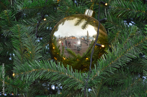 Close-up of a golden ball and garland on a Christmas tree
