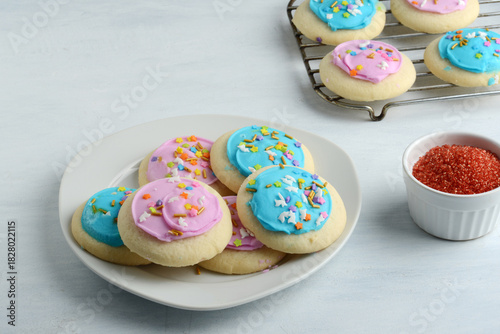 plate of pink and blue sugar cookies with colorful sprinkles
