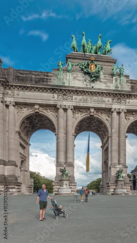 Hyperlapse of the Cinquantenaire Arcade in Jubelpark, Brussels, Belgium. The memorial triumphal arch stands tall under dramatic clouds timelapse, symbolizing Belgian history and independence.