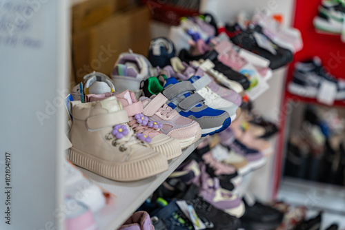 A vibrant assortment of children's shoes on display, showcasing various styles and colors in a retail setting.