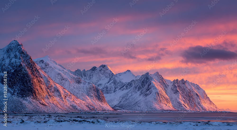 Obraz premium Snow-capped mountain range under vibrant aurora borealis at dusk; natural landscape concept.