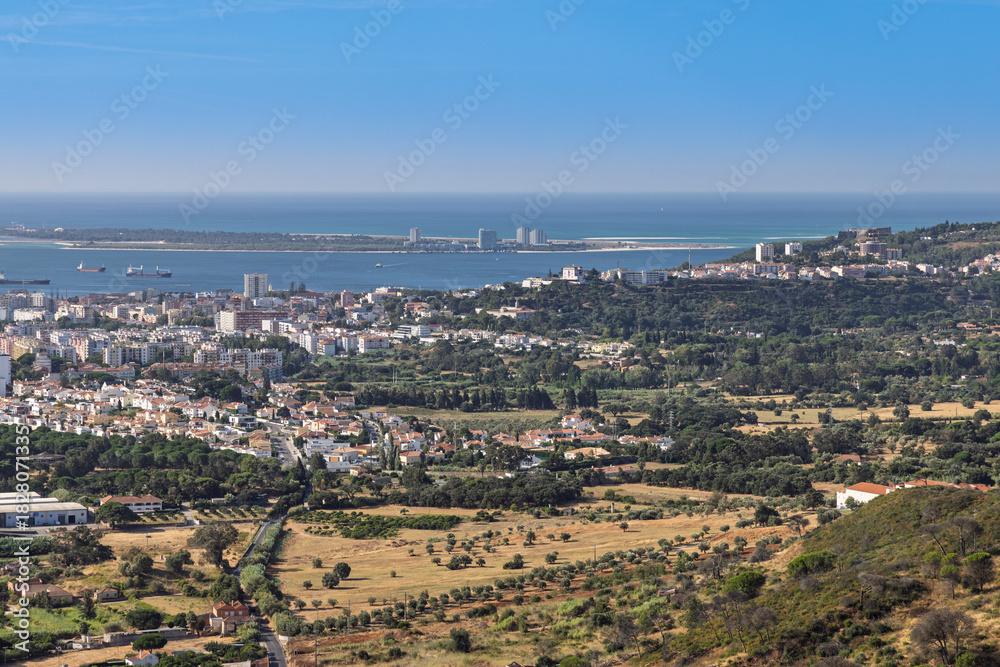 Obraz premium Stunning panoramic view of Setubal, Portugal, overlooking the Sado Estuary and the scenic Tróia Peninsula. A beautiful coastal cityscape.