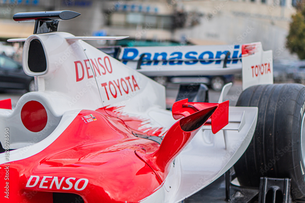 Fototapeta premium Formula 1 Toyota TF-108 car parked on tarmac, predominantly white with red and branding accents Notable features aerodynamic shapes, high rear wing, DENSO sponso - Kyiv, Ukraine 10-10-2024