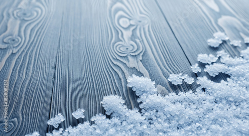 A blue-toned wooden surface with crystalline material. It evokes a sense of coldness and winter, suitable for a background or texture