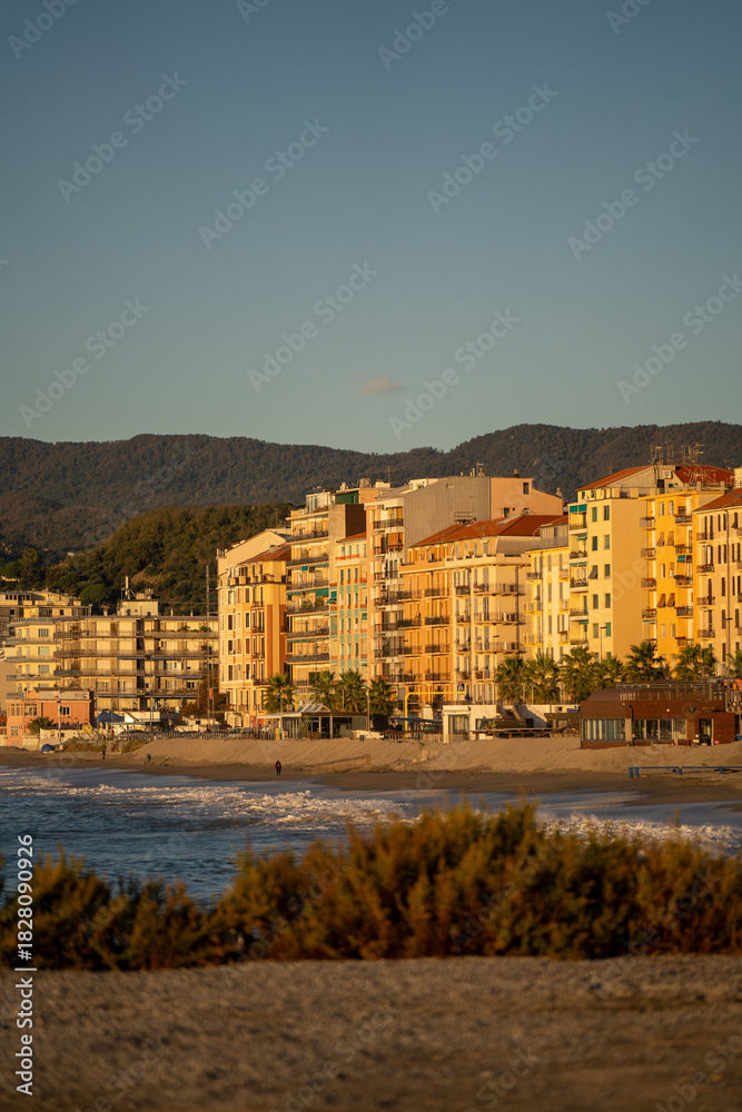 Obraz premium sunrise illuminating shoreline with tranquil ambiance, gentle waves and bright facades at sunrise by beach