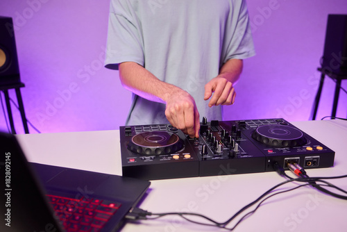 DJ setup overview, Energetic club DJ performing with digital controller in action, Content creator mixing music live using digital turntables under vibrant stage lights