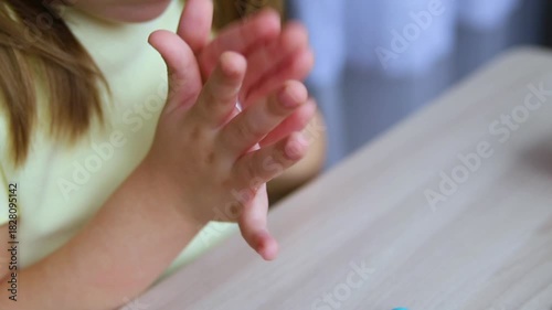 A little girl makes figurines out of colored airy plasticine, modeling dough. Hobbies for children's creativity, educational activities, development of fine motor skills of hands.