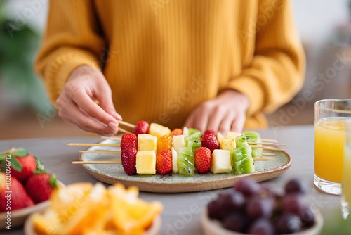 Hands preparing fresh fruit skewers for a healthy gathering