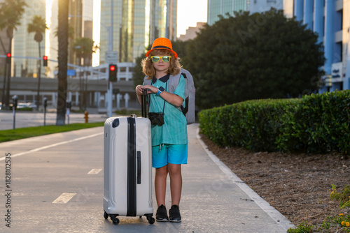 Child traveler with travel bag outdoor. Kids tourism.