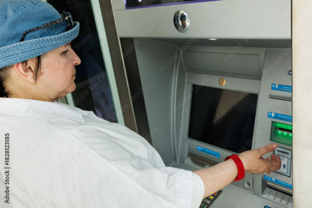 custom made wallpaper toronto digitalTraveler interacts with an ATM, inserting a card into the machine, illustrating banking, finance, payments, and everyday money access while on the go. Stock photo