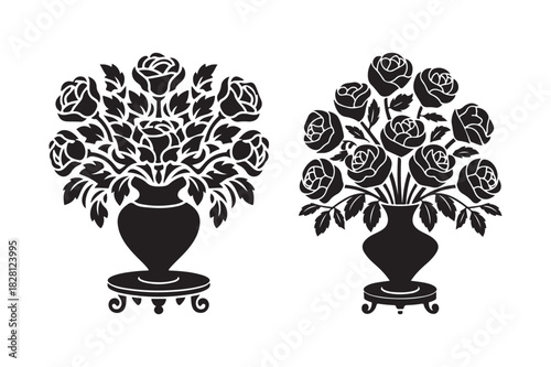 Two black silhouette vases filled with roses on pedestals