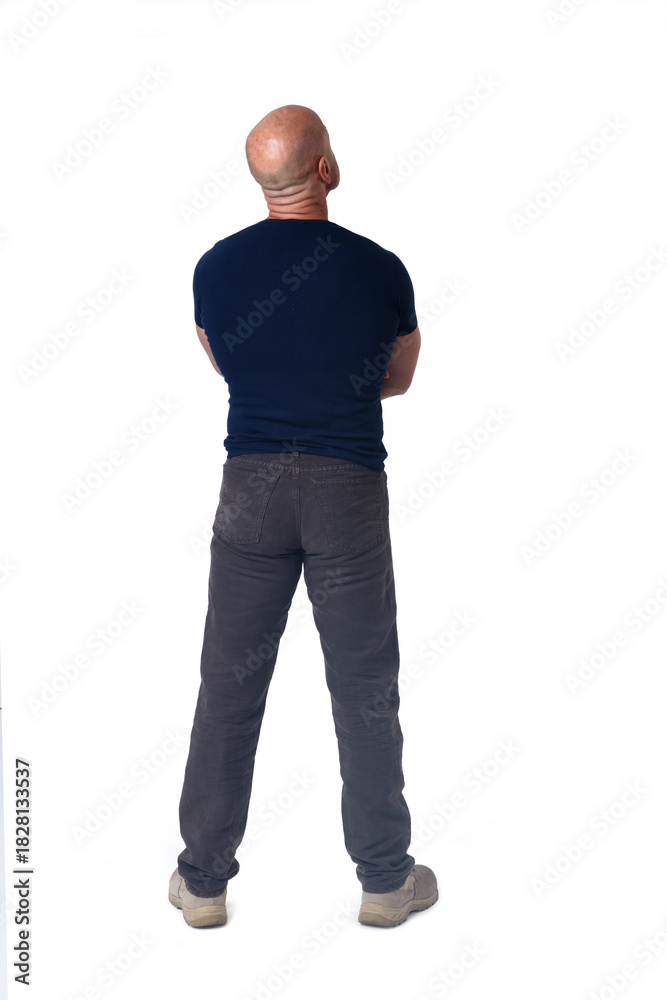 Fototapeta premium back view of a man standing amrs crossed and looking up on white background
