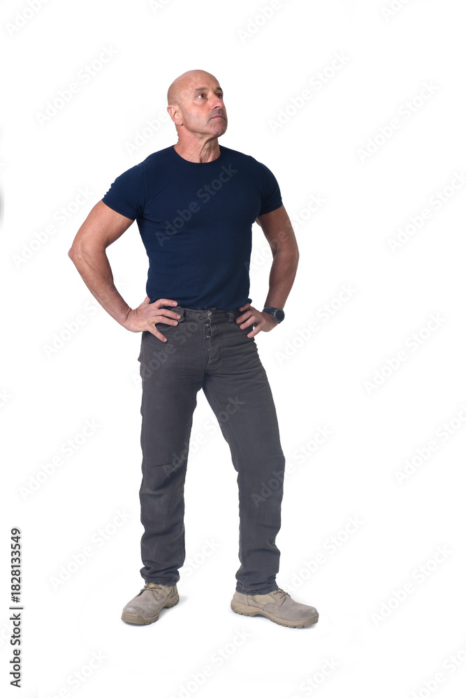 Fototapeta premium view of a man standing amrs akimbo and looking up on white background