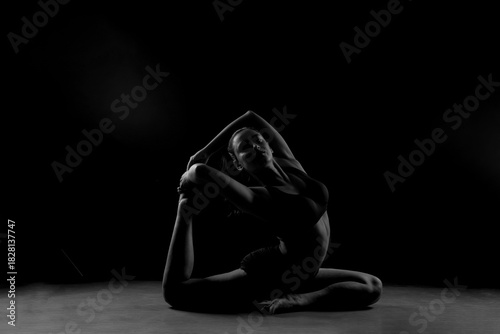 Obraz na plátne Dramatic silhouette of a woman performing an yoga