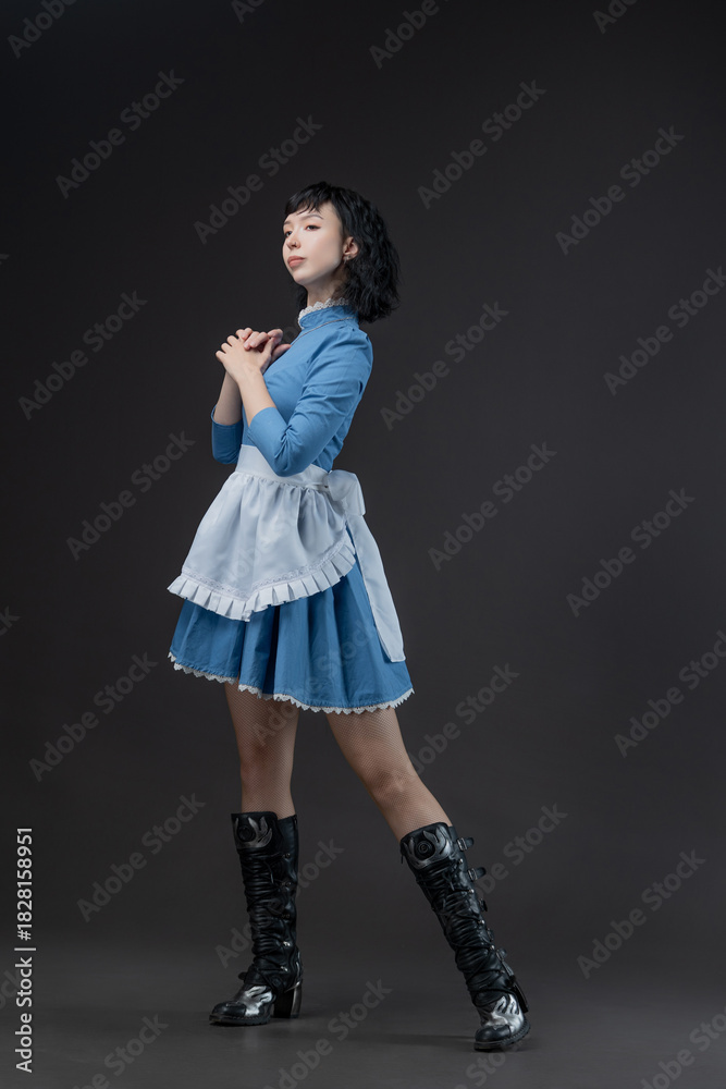 Fototapeta premium Gothic-style woman in blue Victorian dress with apron, Alice in Wonderland theme