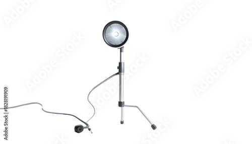 Metal lamp on a tripod casting a bright light on black background
