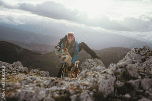 A hiker with a dog during an outdoor trekking excursion in the Abruzzo region of central Italy. The scene features rocky terrain, mountain landscapes and historic stone structures typical of the area