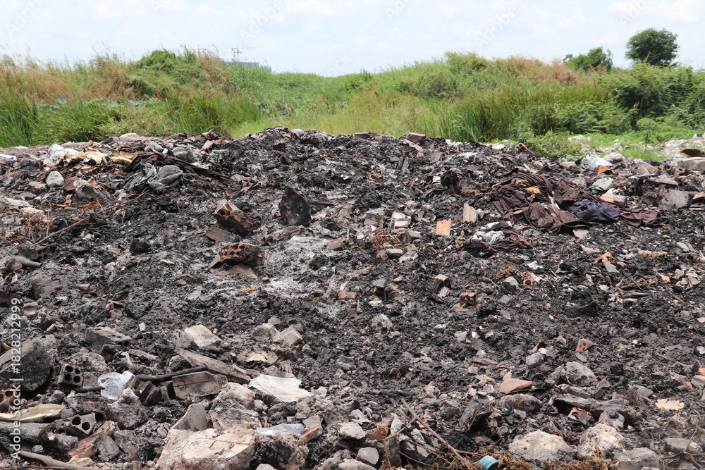 Obraz premium Burned waste pile covering ground with dark ash and scattered debris everywhere