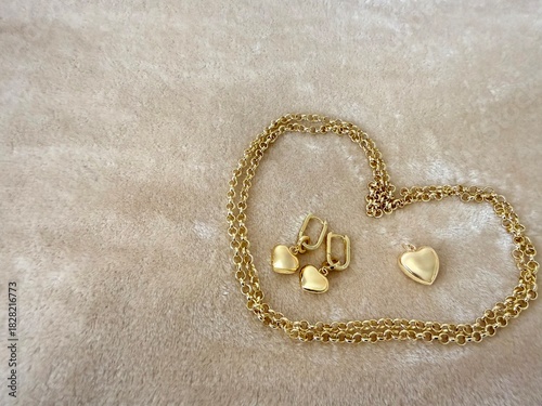 A gold-plated silver jewelry set featuring a delicate chain with a heart pendant and matching heart drop earrings. Elegant accessories for fashion, gifts, and romantic themes