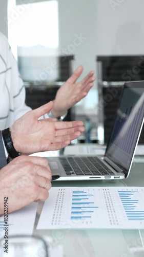 Business meeting discussing financial data and market trends. Professionals analyzing growing bar chart on laptop screen. Planning enterprise growth strategy