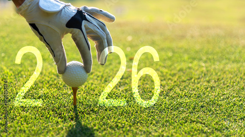 Close up hand Golfer woman putting golf ball for Happy New Year 2026 on the green golf for new healthy.  copy space. Healthy and Holiday Concept