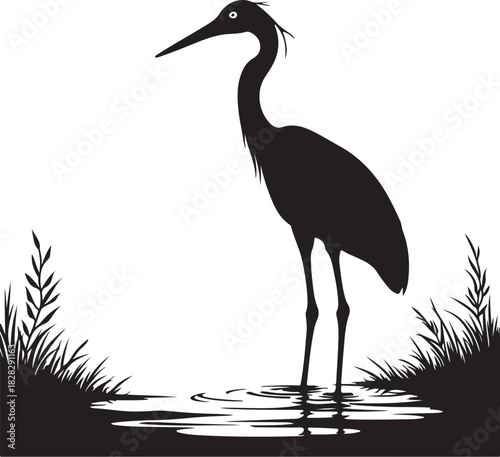 Black silhouette of a heron standing in water with grass