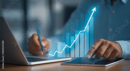 Financial Success and Business Growth with Increasing Bar Chart Data Analysis on Digital Tablet and Laptop