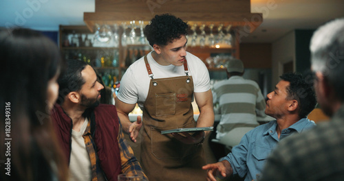 Waiter man, tablet and friends at bar for order, talk and option for drinks, choice and wine list. People, group and server with tech, digital menu app or customer experience with decision at pub