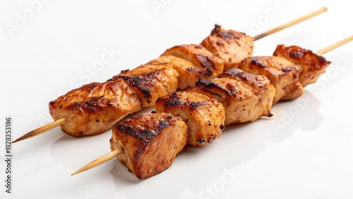 Delicious grilled chicken wings and meat shish kebabs on skewers make a tasty barbecue dish served as a roasted beef and pork dinner plate