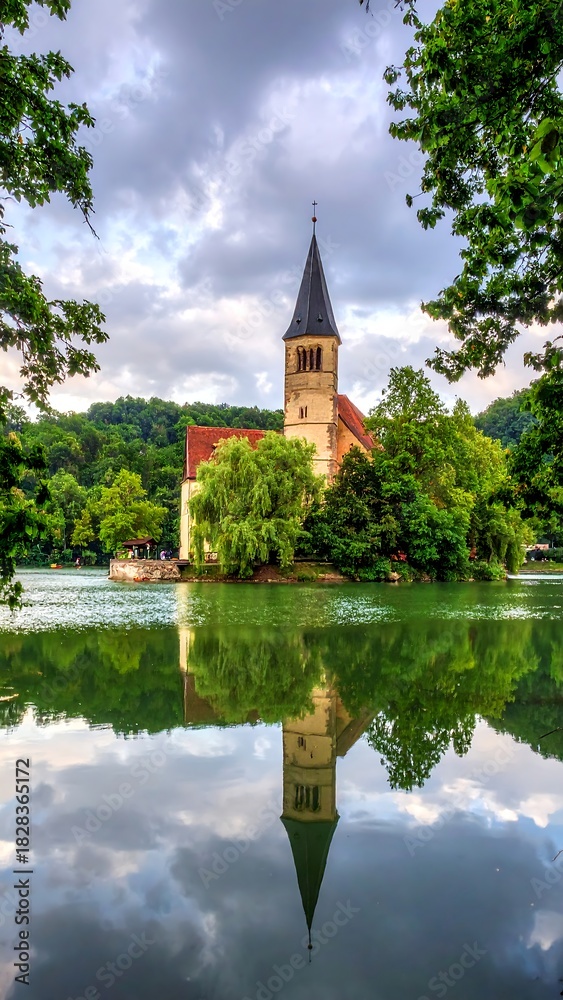 Obraz premium Scenic church on small island with reflection in serene water