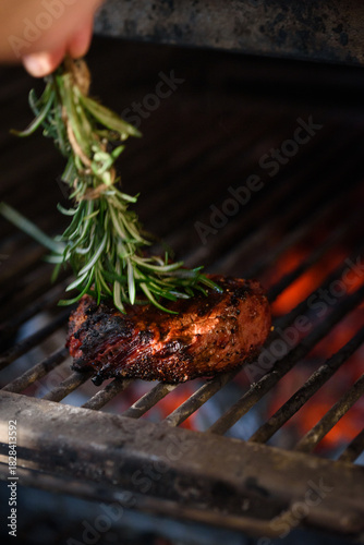 Pepper steak grilled with a sprig of rosemary