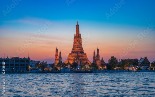 Sunset view of the Phra Prang of Wat Arun from Wat Pho pier in Bangkok, Thailand.