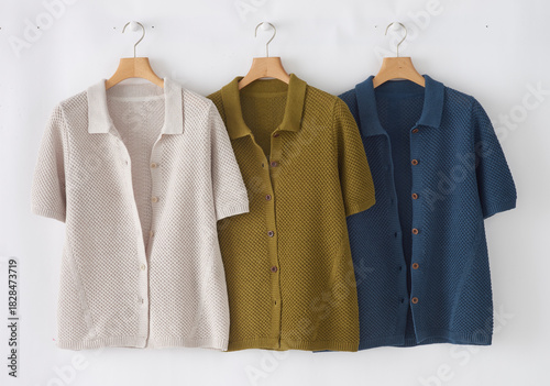Knitted short sleeve polo shirts in neutral colors hanging on hangers