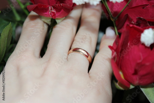 Couple celebrates their engagement with a beautiful ring and red roses in a cozy setting