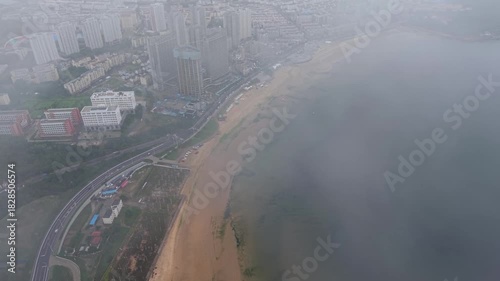 Dramatic foggy coastal city reveal with radar station, aerial China
