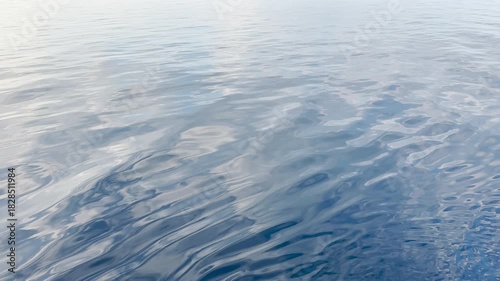 Tranquil Waters: Serene Blue-Grey Ocean Surface Under Gentle Sunlight. HDR Video, Seamless Loop