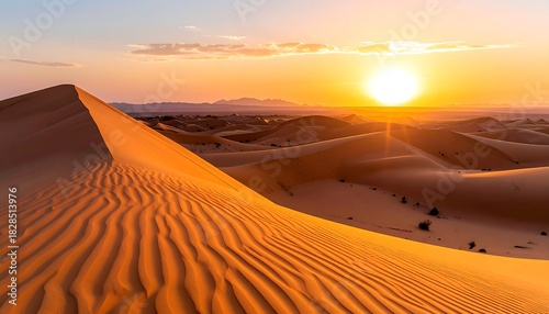 Desert landscape with sun rising behind dunes, creating orange/yellow glow over sand