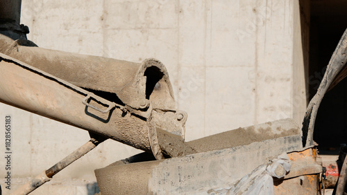 A concrete pump is pouring fresh concrete onto a construction site