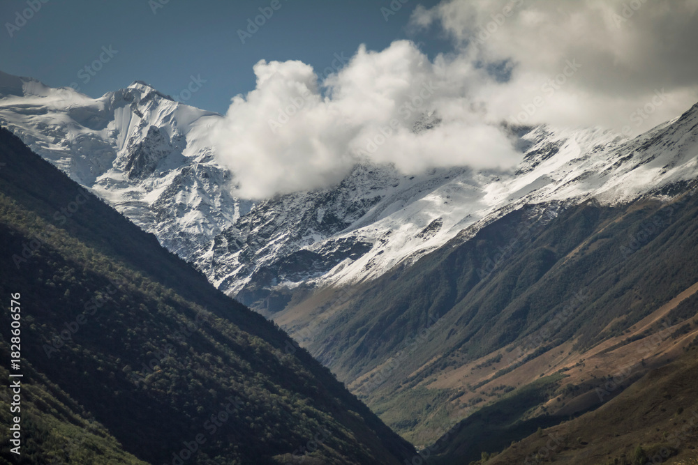 Fototapeta premium Peaks of the Caucasus Mountains in snow and clouds