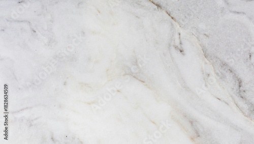 Close up shot of a white marble surface with subtle gray and beige veining pattern throughout the stone
