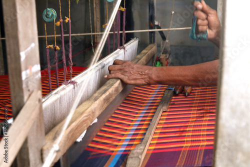Man weaving Saree  on a traditional wooden handloom in tamilnadu