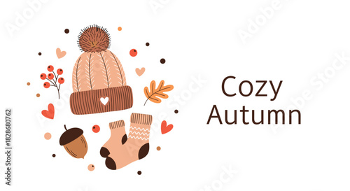 A charming 'Cozy Autumn' illustration featuring a knitted hat warm socks an acorn and berries arranged in a cute circular composition.