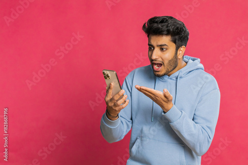 Fotografie Upset sad Indian man use smartphone typing browsing, play game, loses, surprised by sudden lottery results bad fortune loss fail unlucky news