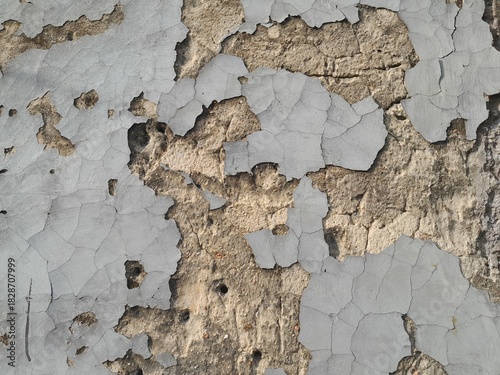 The surface of the old house walls is cracked and the cement plaster is peeling off.